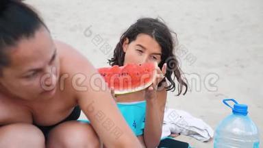 孩子们，青少年在海滩上休息，笑着<strong>吃西瓜</strong>，慢动作<strong>视频</strong>。 女孩少年休息